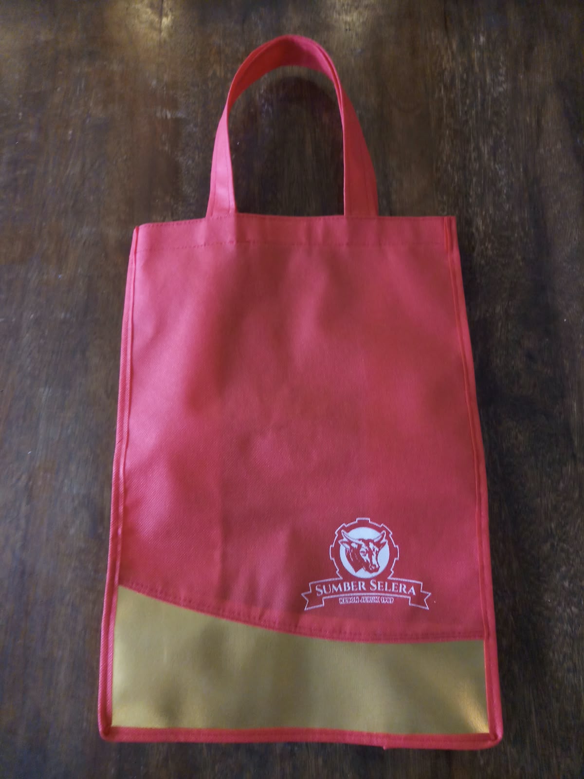 Goodie bag merah muda dengan detail emas